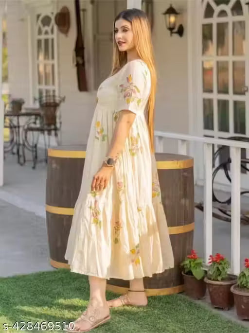 This kurti features a flowing, Anarkali-style design with a cream-colored base and floral hand-painted motifs